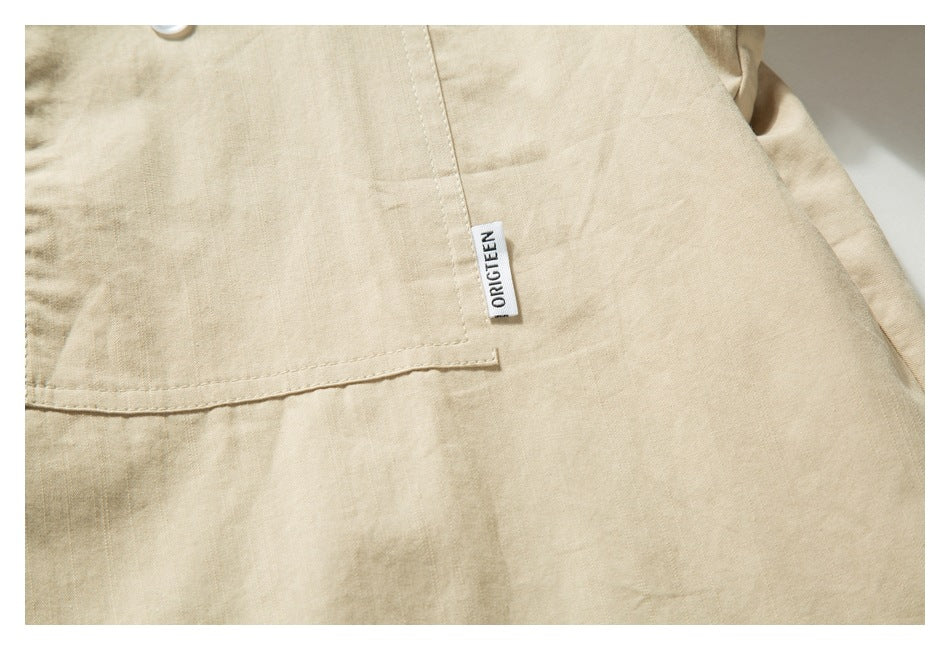 Close-up of a beige shirt pocket seam and a small sewn ORIGTEEN label.