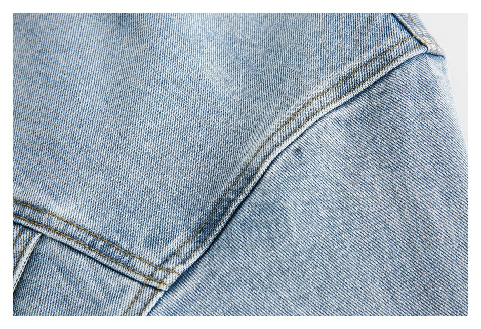 Close-up of curved double-stitched seams on faded blue denim.