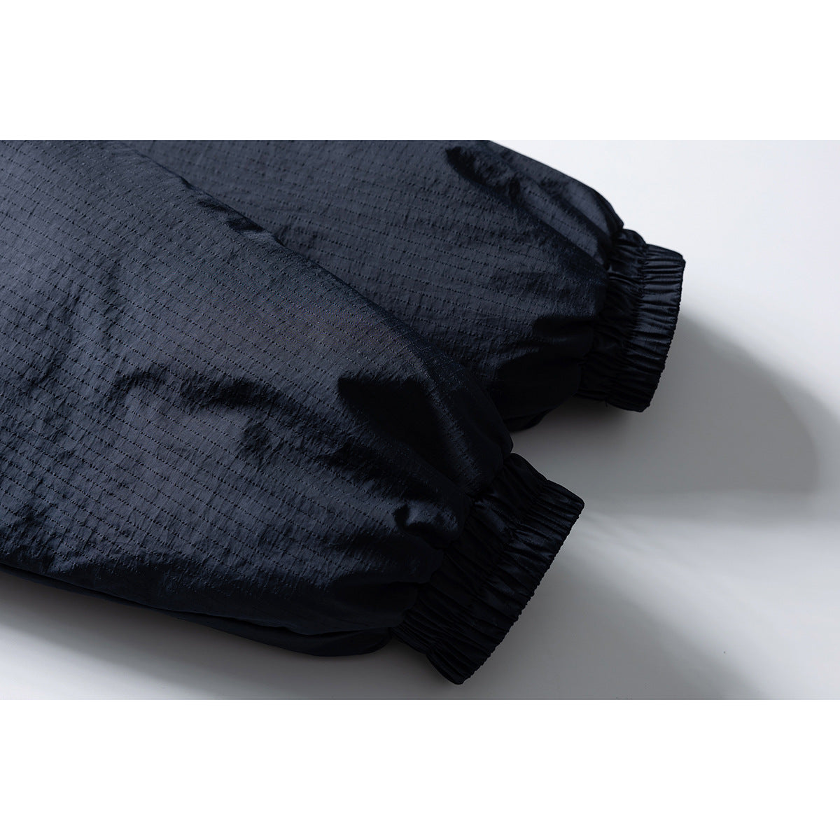 Close-up of the dark jacket’s textured sleeve and gathered elastic cuffs.
