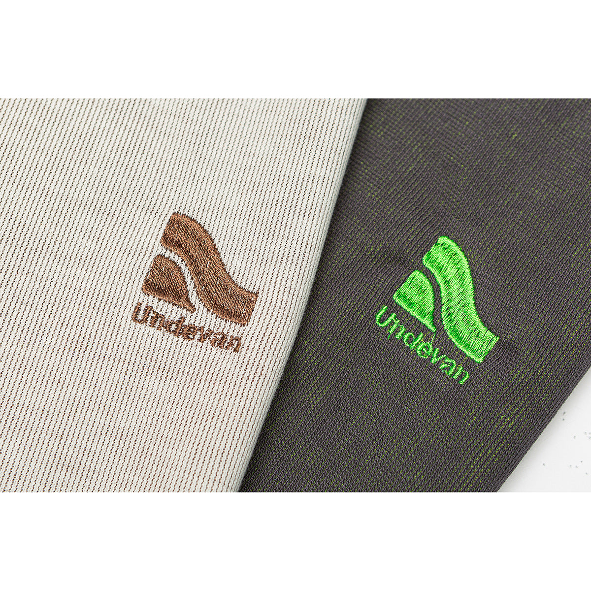 Close-up of small embroidered logos on cream and charcoal knit fabric.