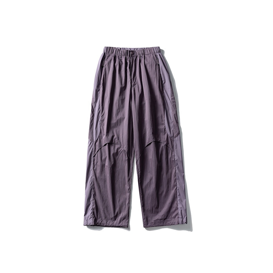 Front view of muted lavender wide-leg pants with an elastic waistband, pockets, and curved panel seams.
