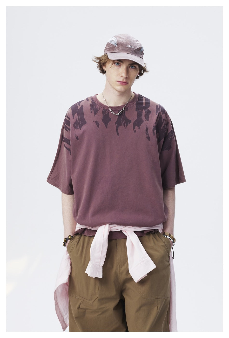 Closer front view of a model wearing a mauve oversized graphic T-shirt and olive cargo pants.