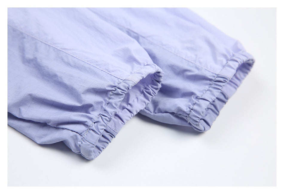 Close-up of lavender garment fabric showing two elasticized hems and visible stitching.