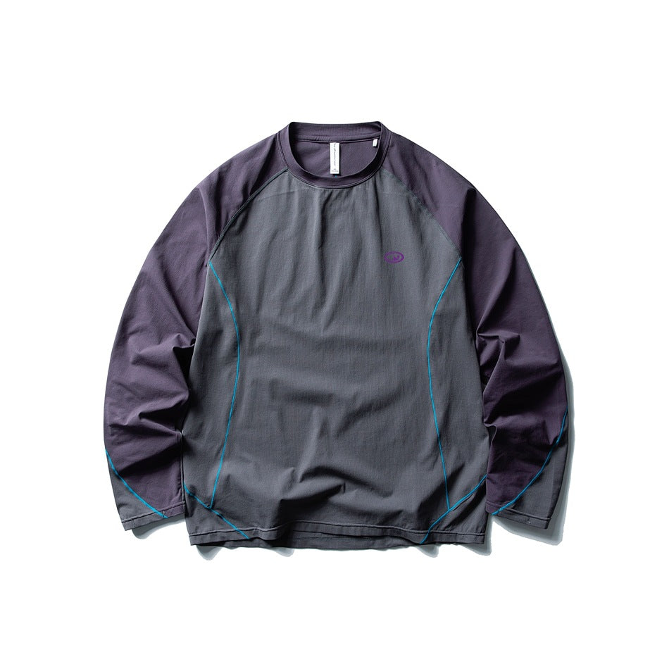 Gray long-sleeve top with dark purple raglan sleeves and collar, teal piping and small purple chest logo, flat lay