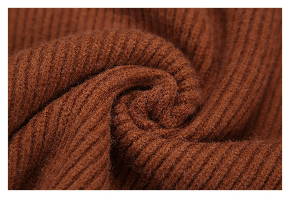 Close-up of rust-brown ribbed knit fabric gathered into a soft spiral.