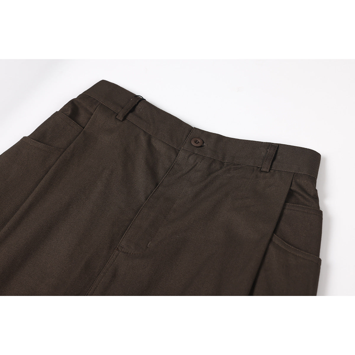 Close-up of dark brown trousers showing the front waistband, button, belt loops, and pocket opening.