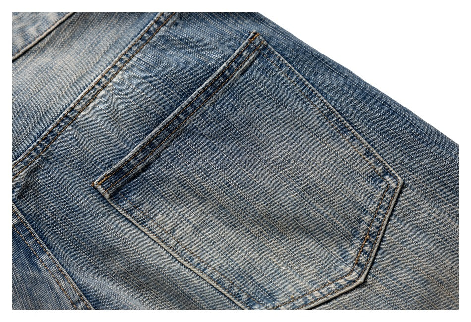 Close-up of a back pocket on faded blue jeans, with visible seams and contrast stitching.