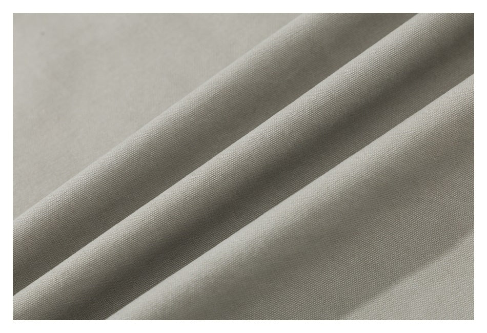 Close-up of light khaki woven fabric arranged in soft folds.