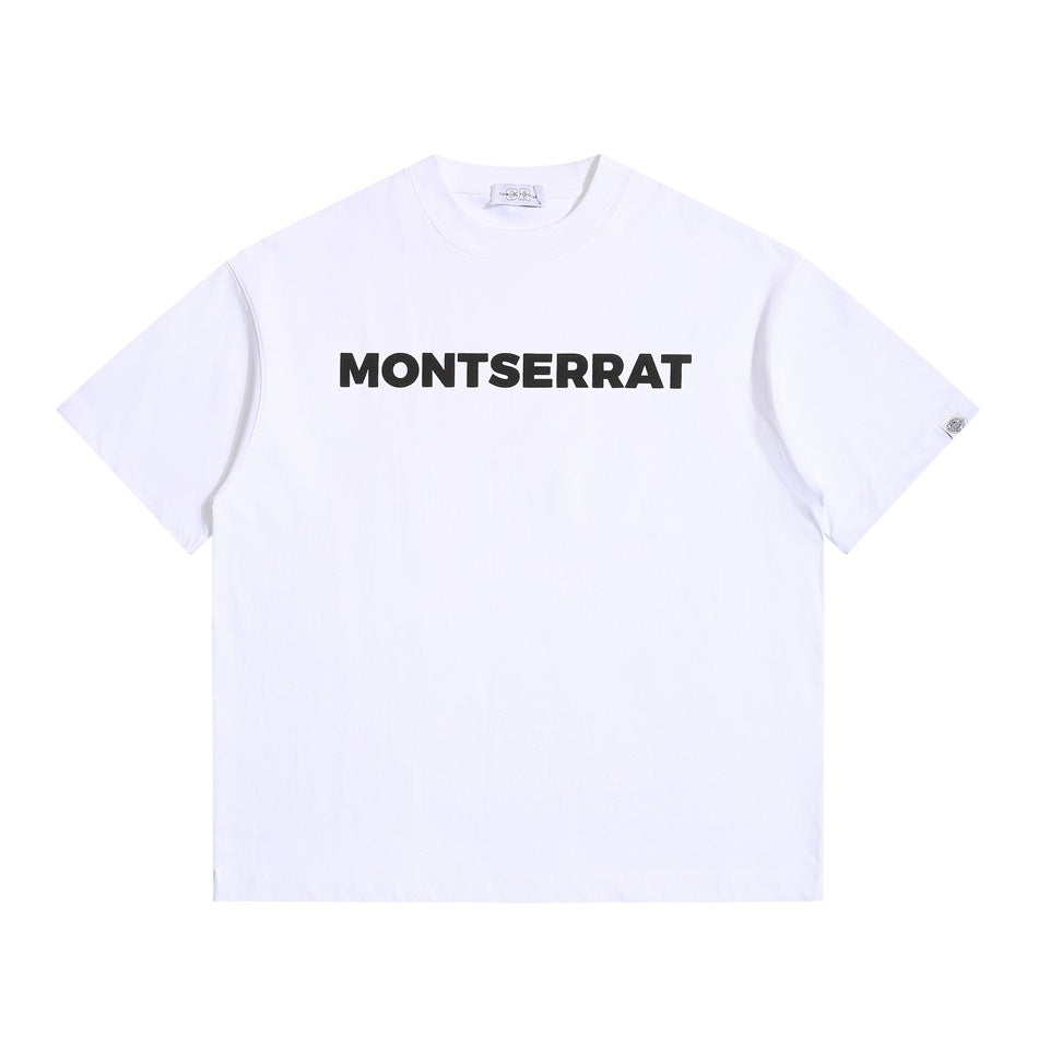 White short-sleeve crewneck T-shirt with black MONTSERRAT block lettering on the chest, flat lay