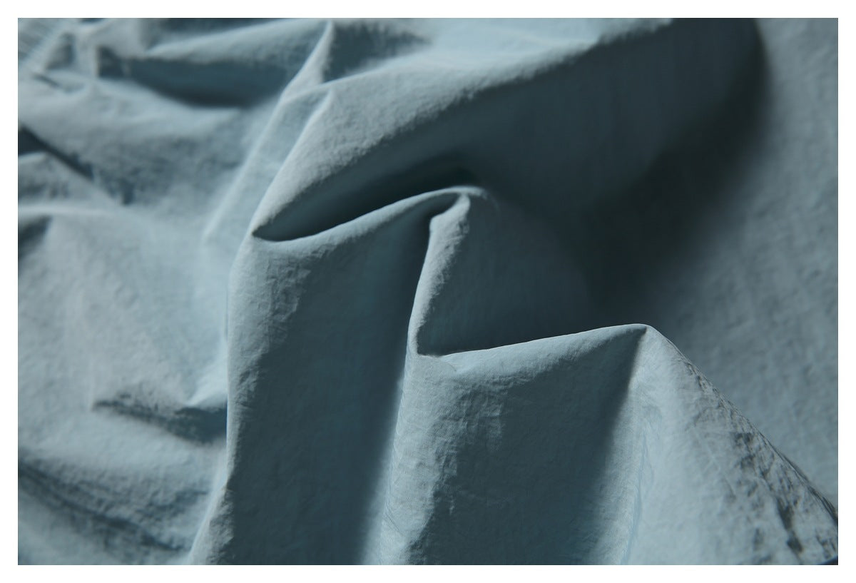Macro view of the softly creased blue-gray shorts fabric.
