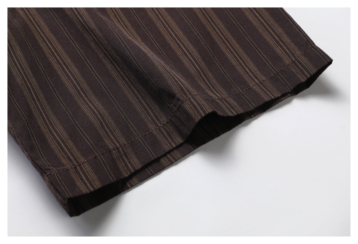Close-up of the dark brown shirt's striped fabric and stitched hem.