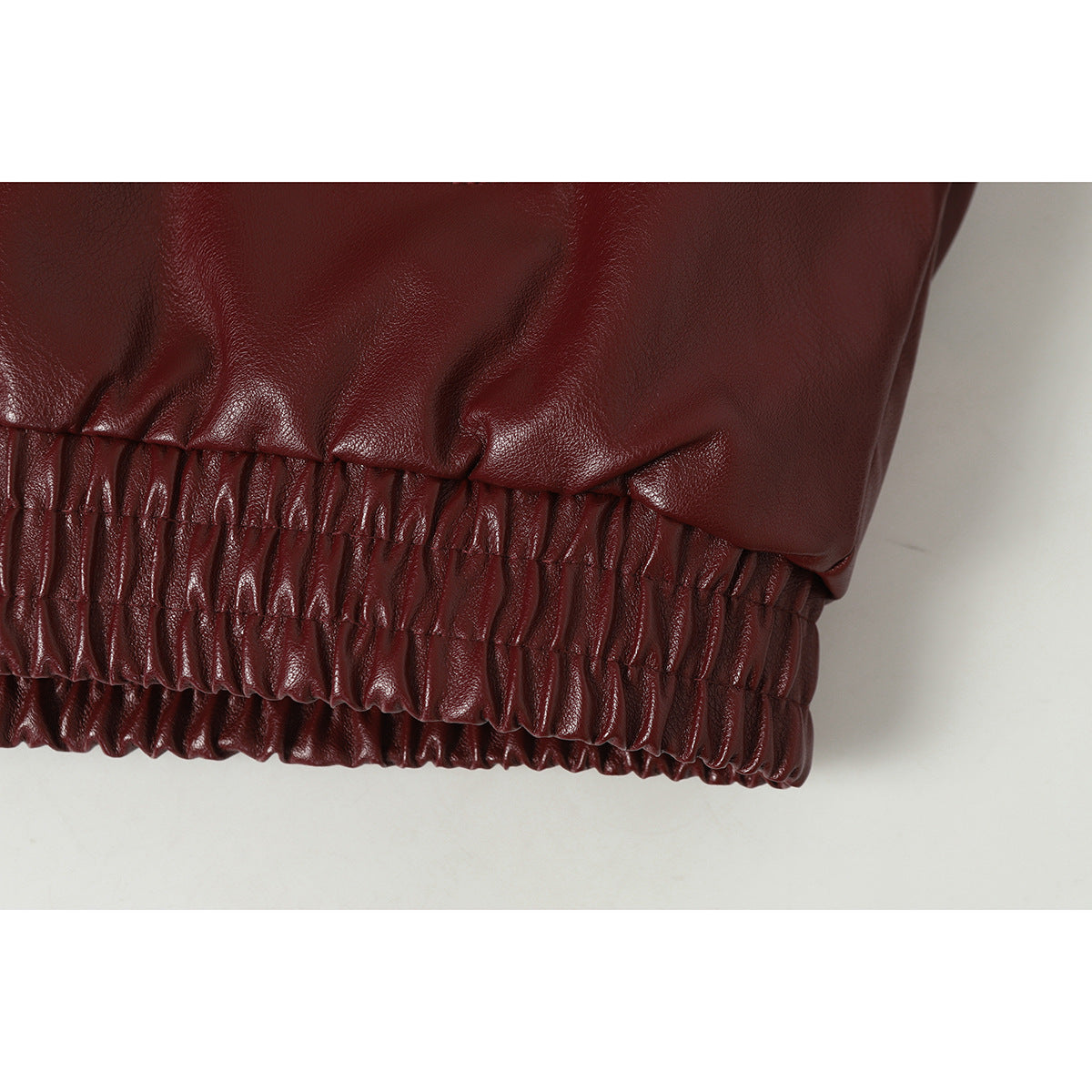 Close-up of the burgundy jacket's gathered elastic hem.