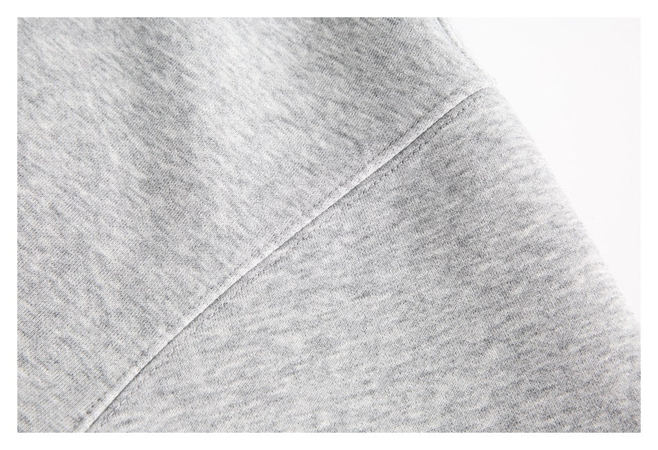 Close-up of a seam on the heather-gray hoodie against a white background.