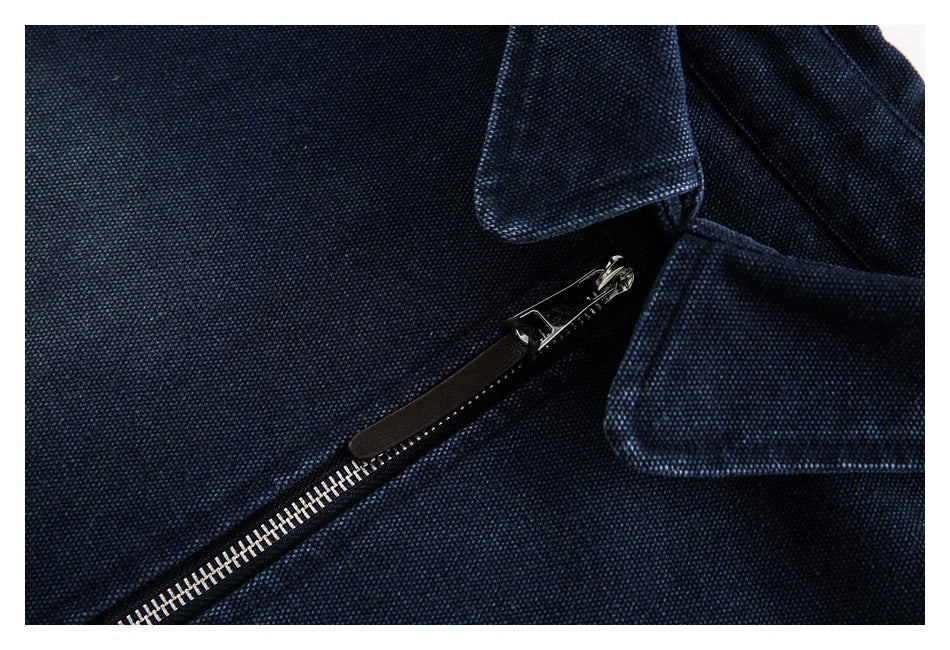 Close-up of the silver front zipper and pointed collar on a navy garment.