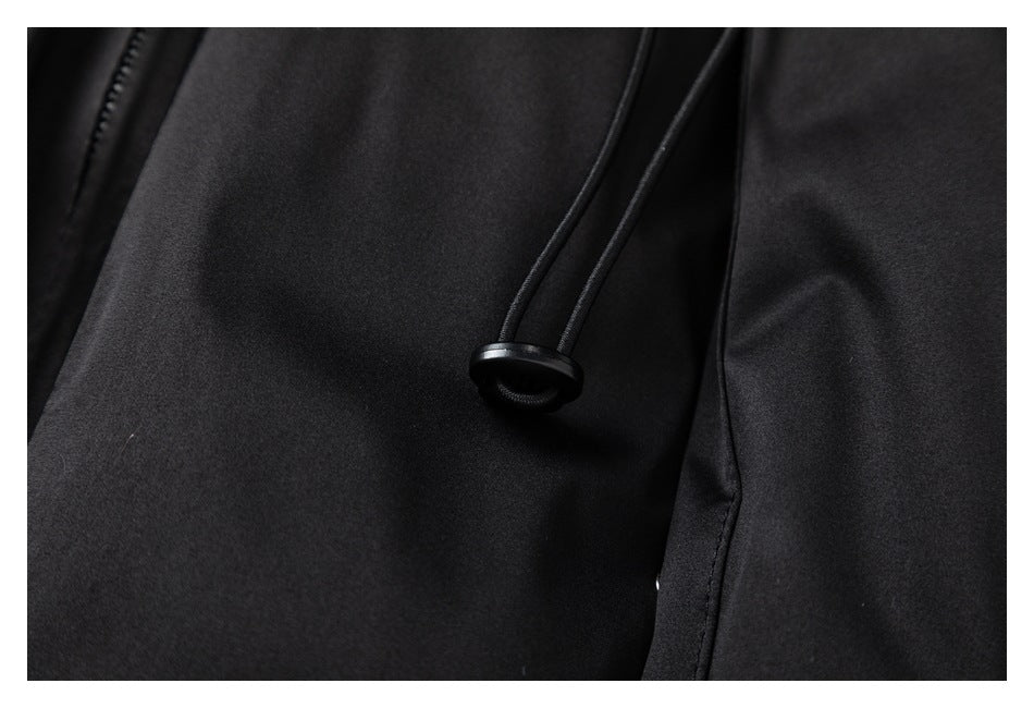 Close-up of a black drawcord and toggle against the jacket fabric.