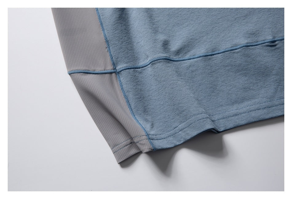 Close-up of a blue garment hem with a gray textured side panel and blue seam stitching.