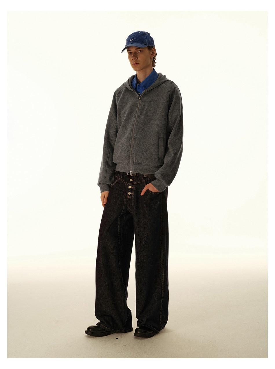 Model wearing a gray zip-front hooded sweatshirt over a blue shirt, with dark wide-leg jeans.