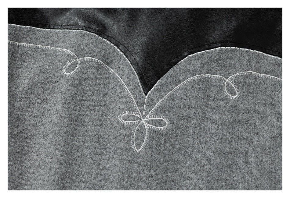 Close-up of the gray-and-black jacket back with curved panels and white loop embroidery.