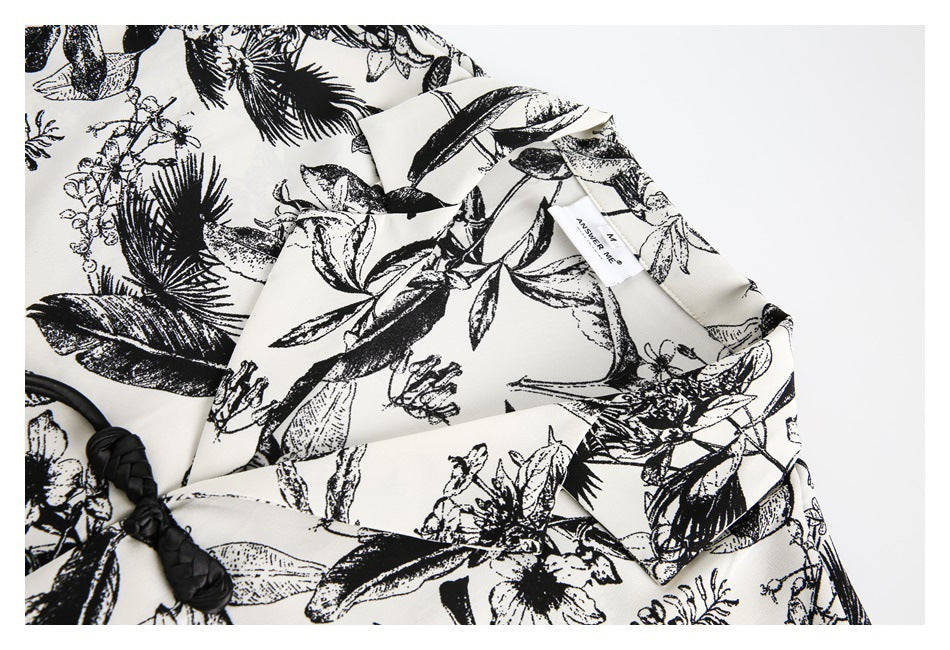 Close-up of the shirt's pointed collar, black botanical print, and a small sewn-in neck label.