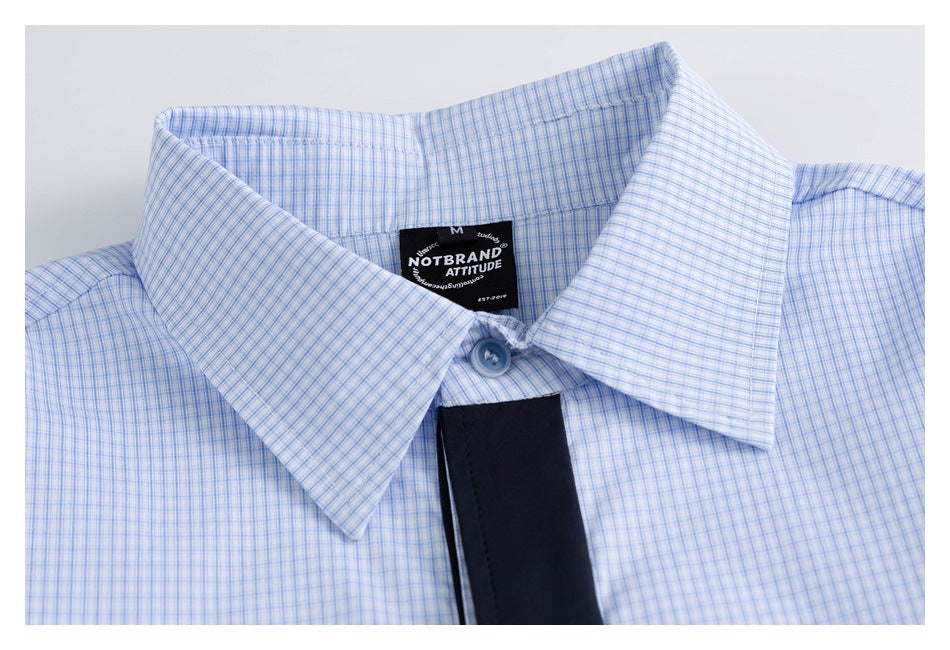 Close-up of the collar and neck label on a light blue fine-check shirt.