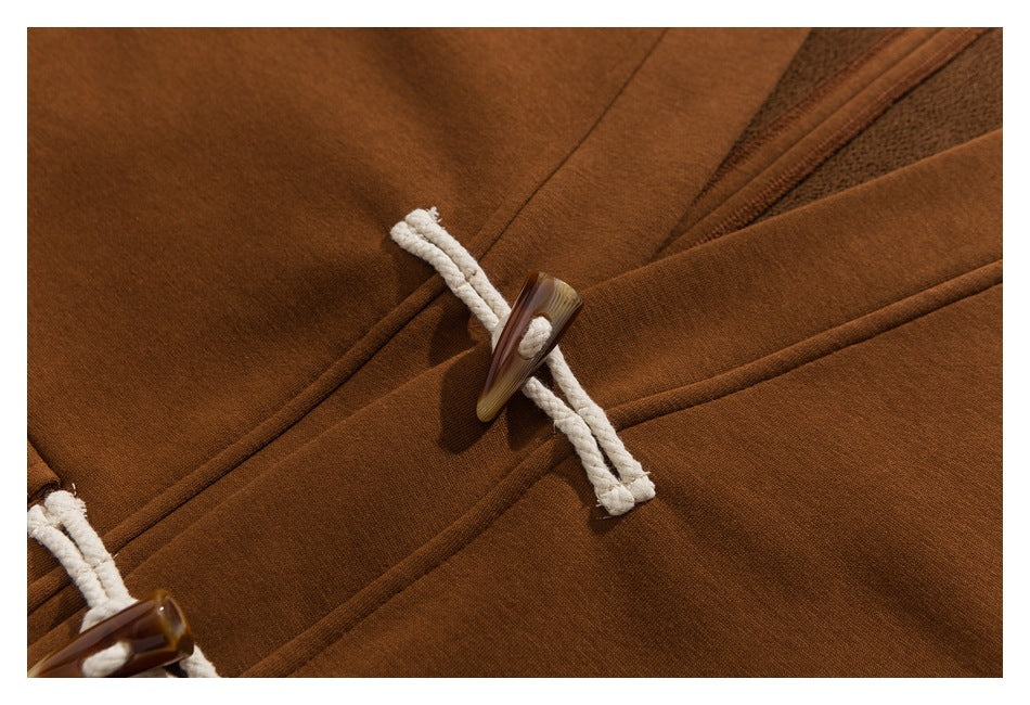 Close-up of a brown garment's white rope loop and brown toggle closure.