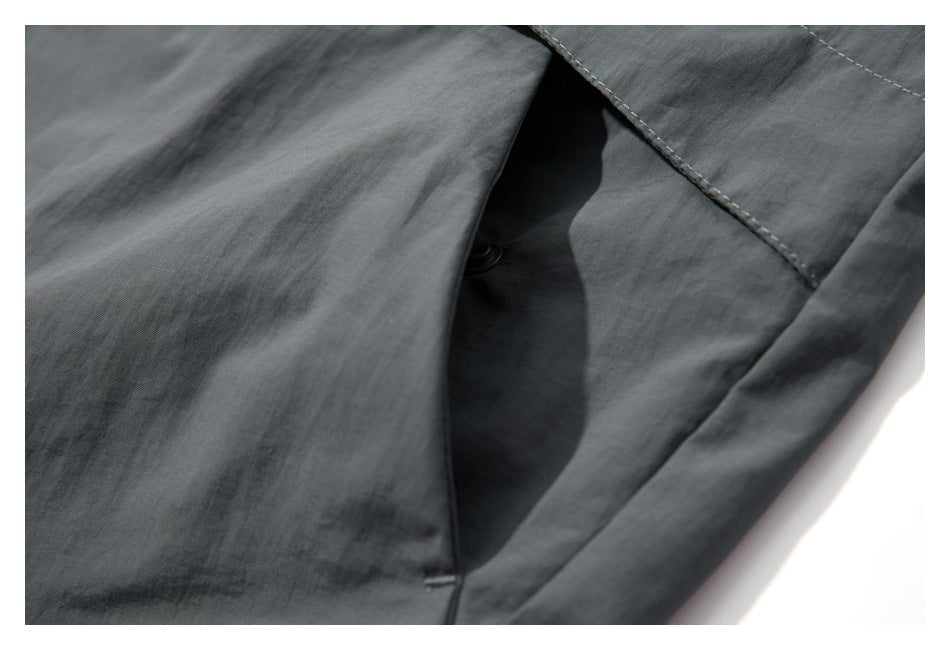 Close-up showing the opening and interior of a pocket on a dark gray jacket.