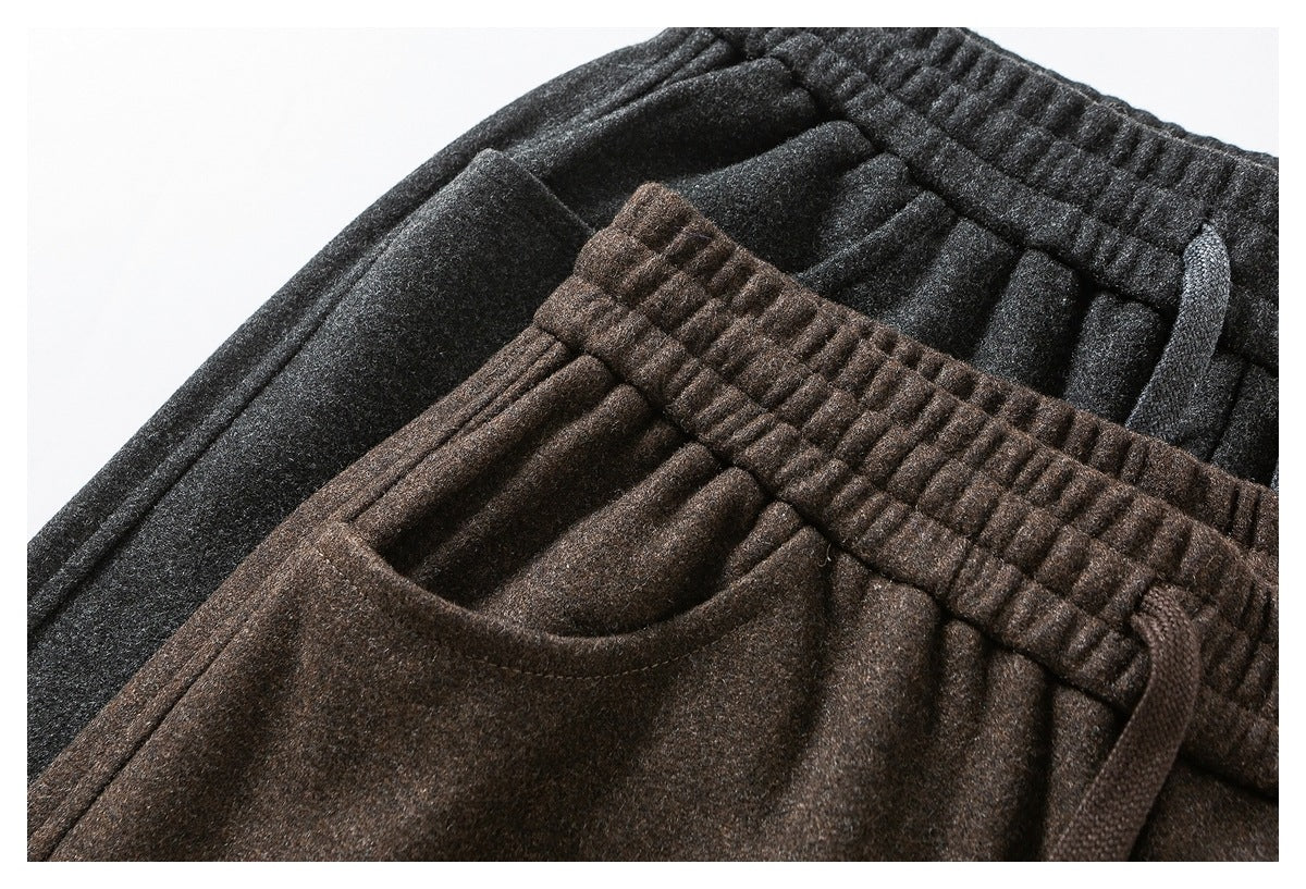 Close-up of charcoal and brown pants showing elastic drawstring waistbands and front pockets.