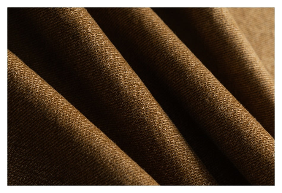 Extreme close-up of the brown fabric's woven texture, arranged in soft folds.