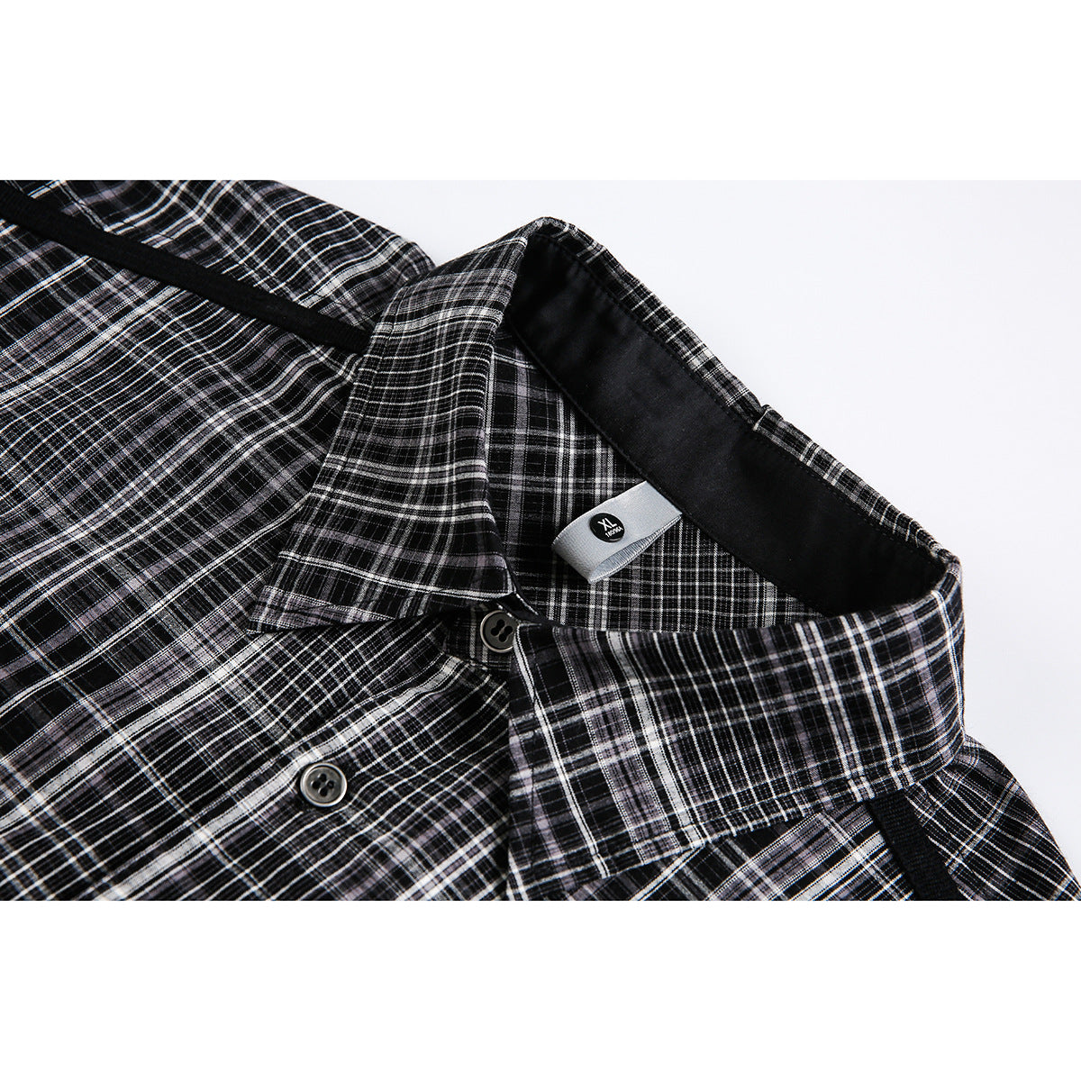 Close-up of a black-and-white plaid shirt collar, buttons, black trim, and an XL neck label.