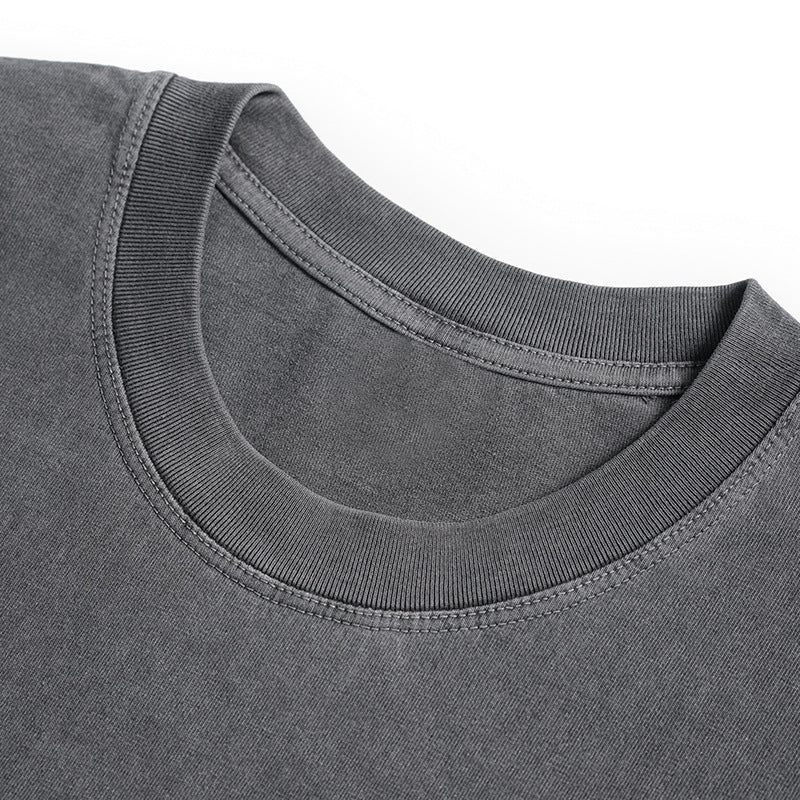 Close-up of a charcoal gray T-shirt's ribbed crew neckline and stitching.