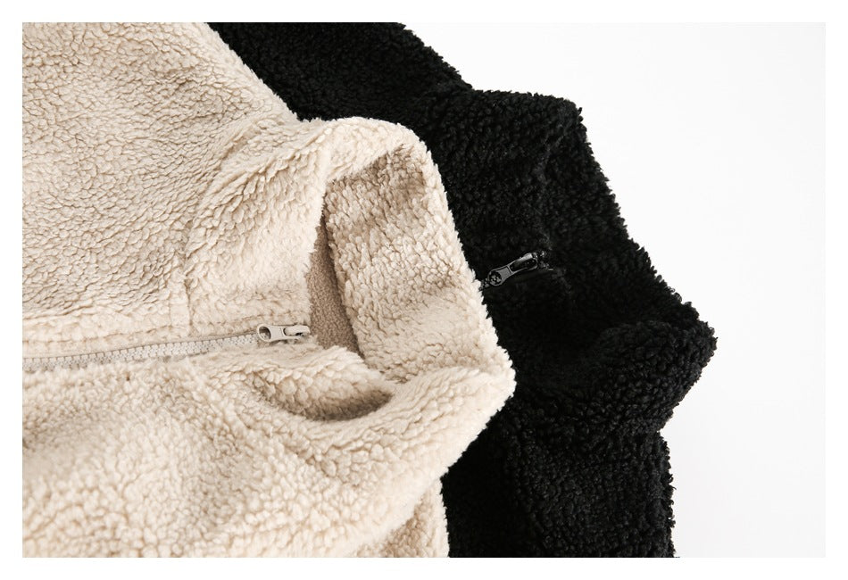 Close-up of cream and black fuzzy zip-up jackets, showing their collars and zippers.