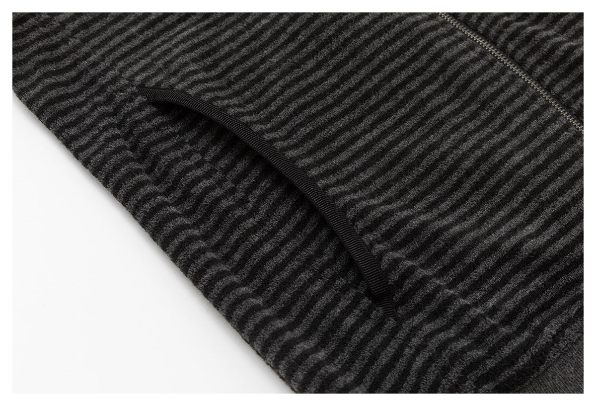 Close-up of a curved pocket opening on the charcoal and black striped jacket.