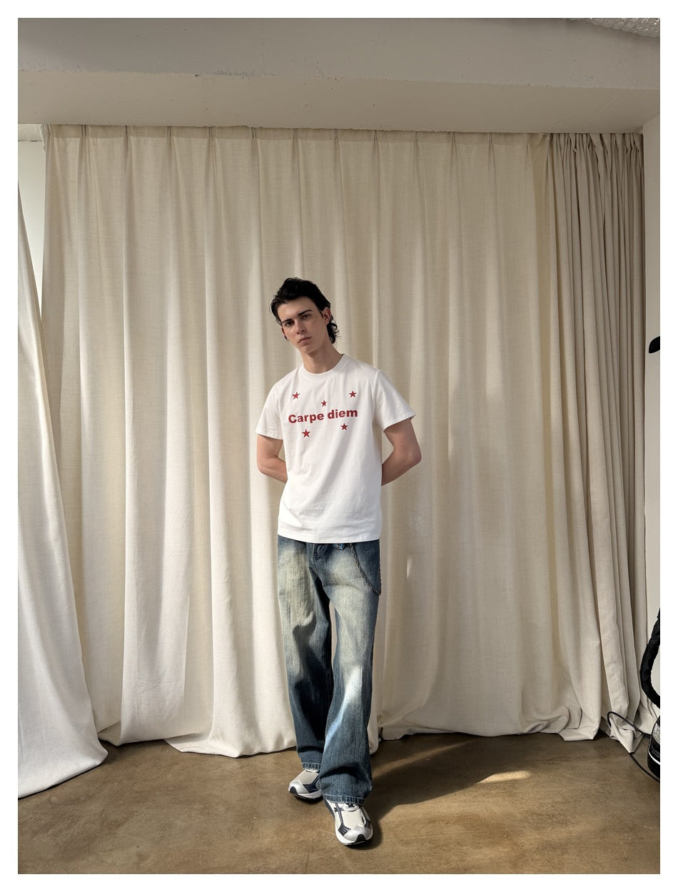 Full-length model wearing a white Carpe diem star-print T-shirt, loose faded jeans, and sneakers.