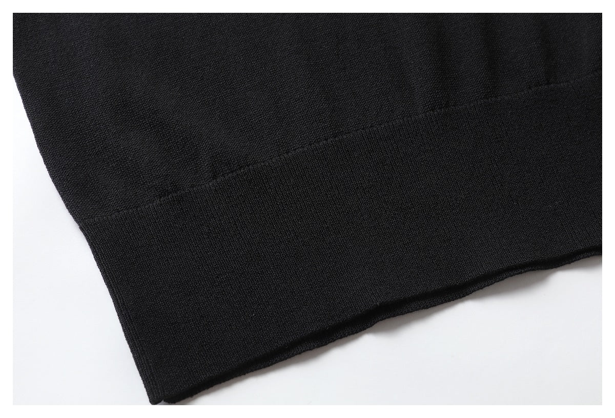 Close-up of a black garment's plain folded hem and knit texture.