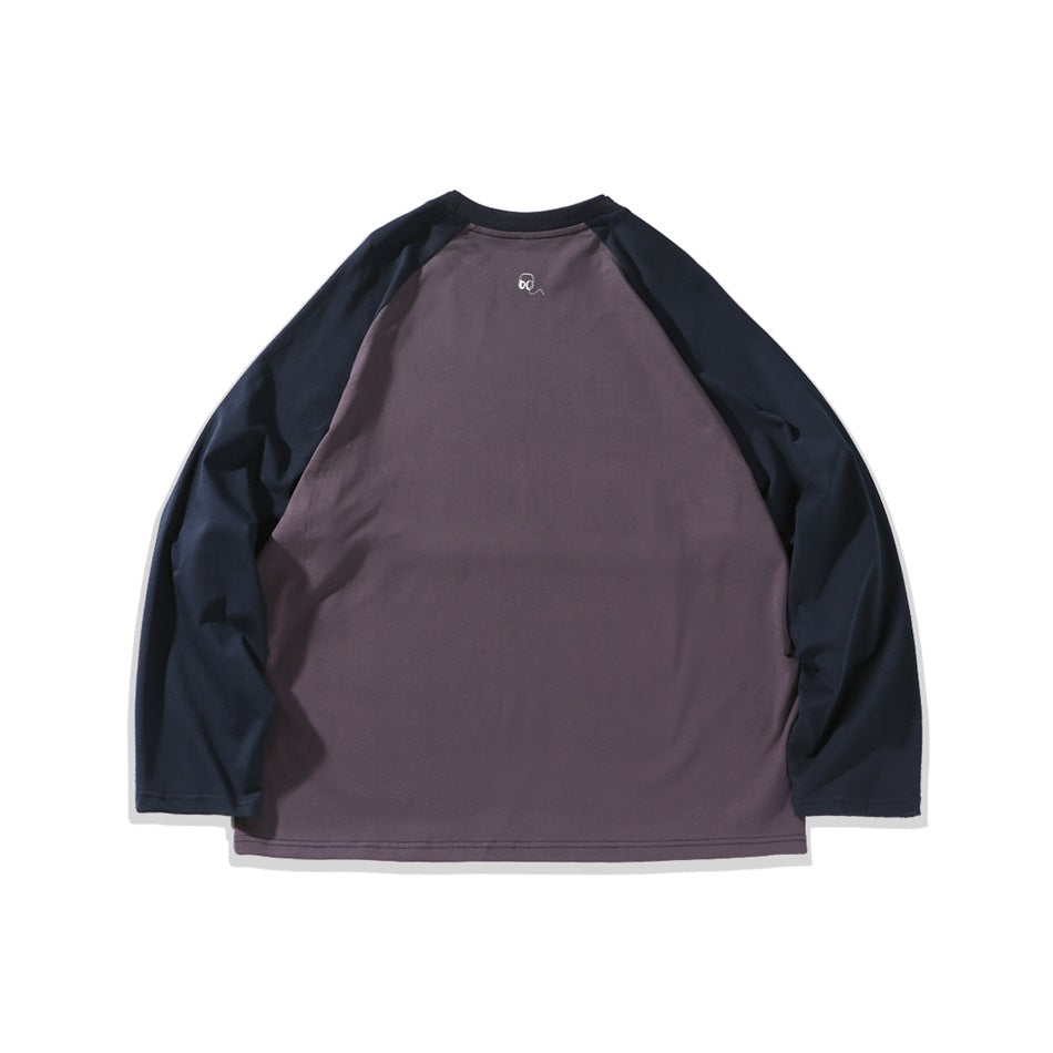 Back of a two-tone raglan long-sleeve shirt, with a muted plum body, dark navy sleeves, and a small white graphic below the