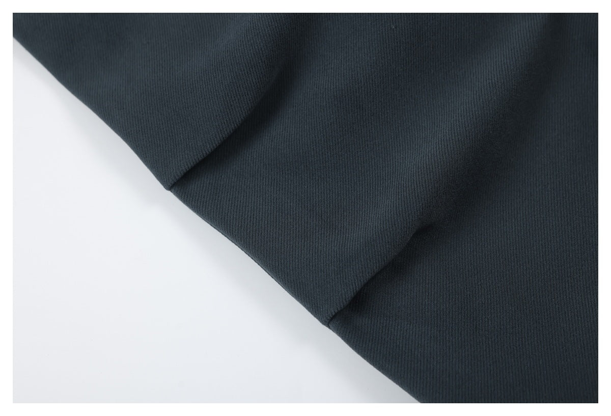 Close-up of a dark charcoal garment showing a diagonal seam and smooth fabric panels.