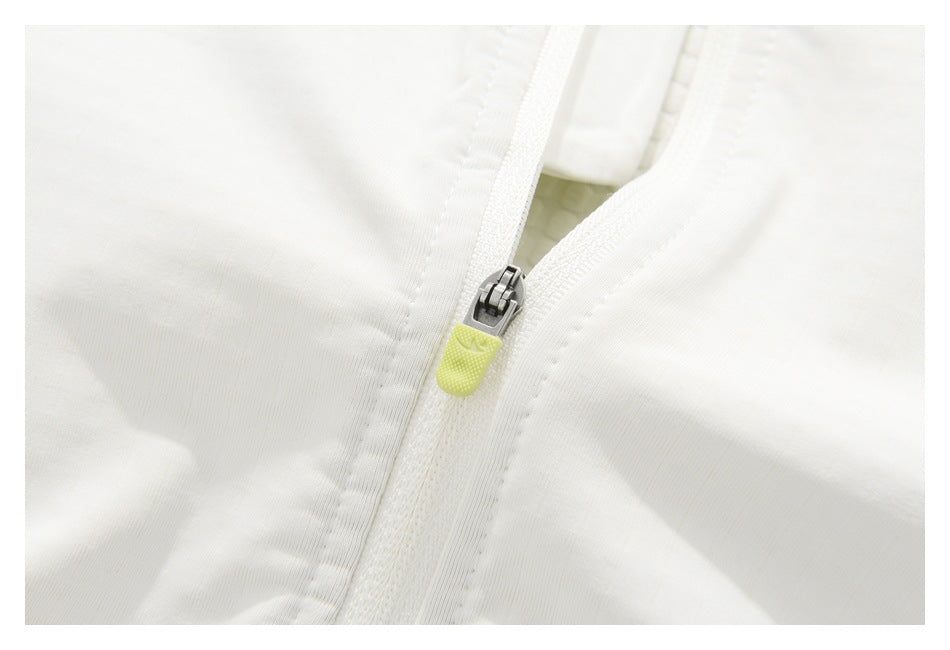 Close-up of a white jacket zipper with a textured yellow pull tab.