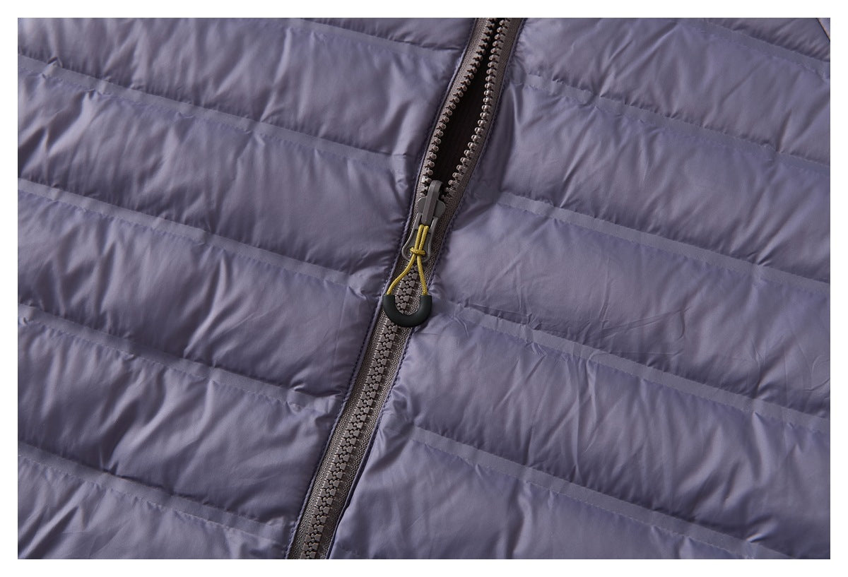 Close-up of the lavender-gray jacket's horizontal quilting and front zipper with a corded pull.