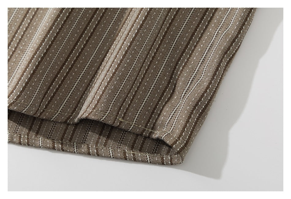 Close-up of the hem and stitching on a brown shirt with narrow cream stripes.