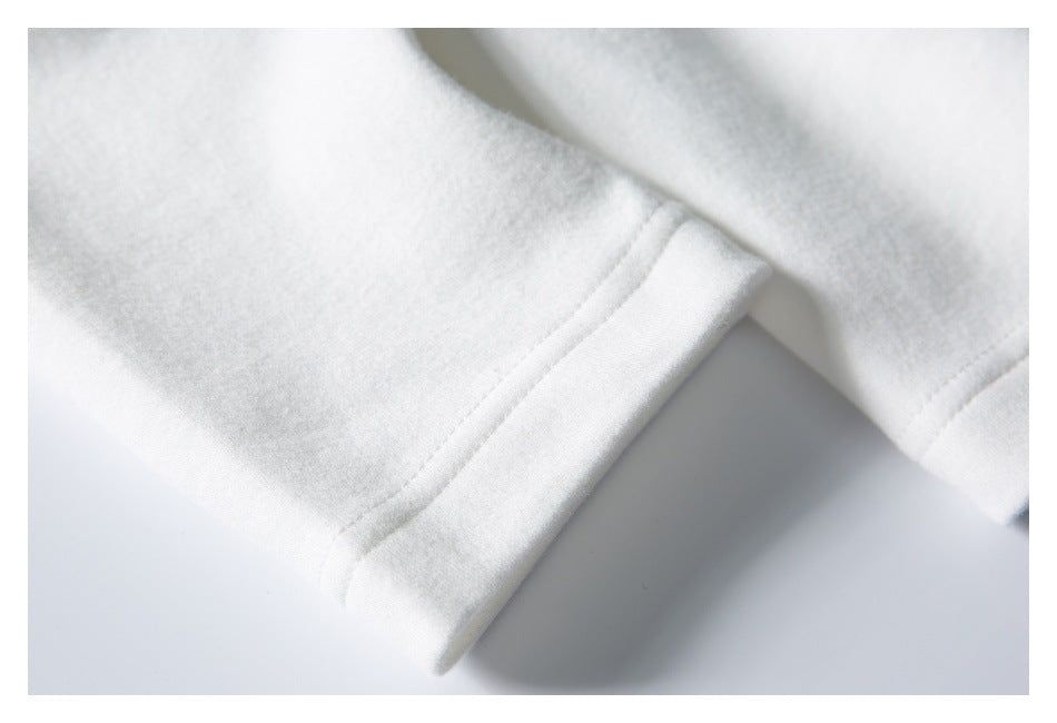 Close-up of a white garment sleeve cuff with a wide folded hem and visible stitching.