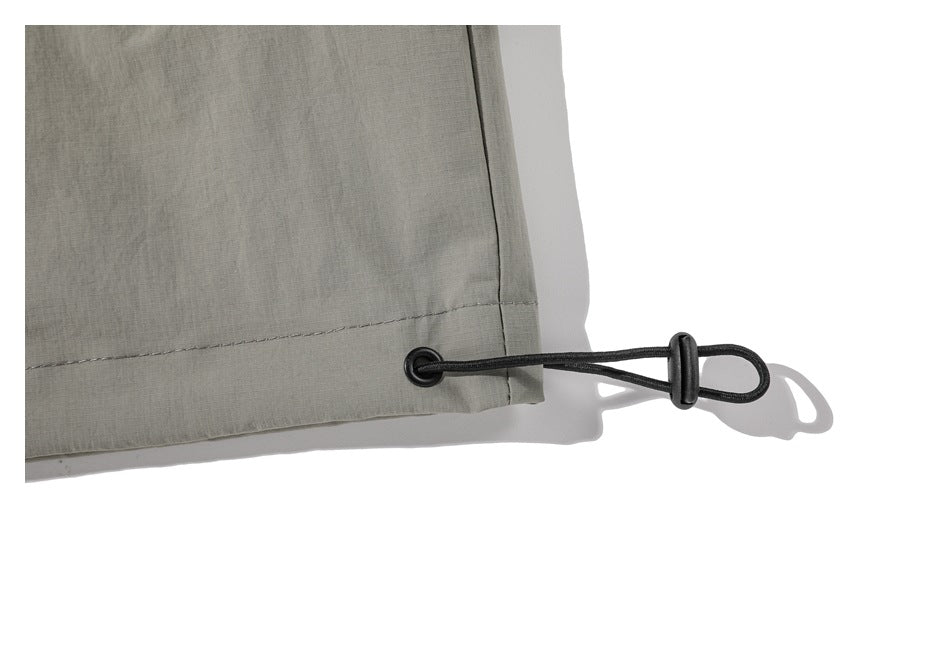 Close-up of the jacket hem with a black elastic drawcord and toggle.