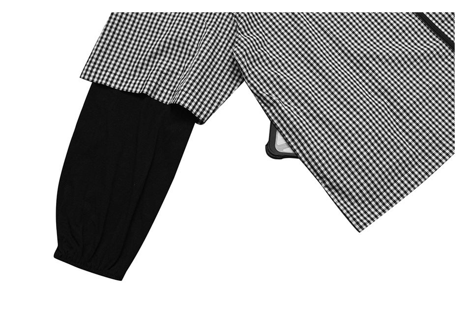 Close-up of a black sleeve with an elastic cuff beside black-and-white gingham fabric.
