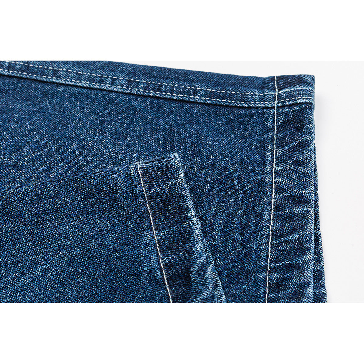 Close-up of blue denim shorts showing a belt loop, waistband stitching, and a vertical seam.