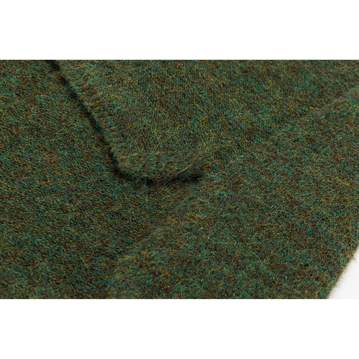 Close-up of mottled green-brown knit fabric with a folded seam.