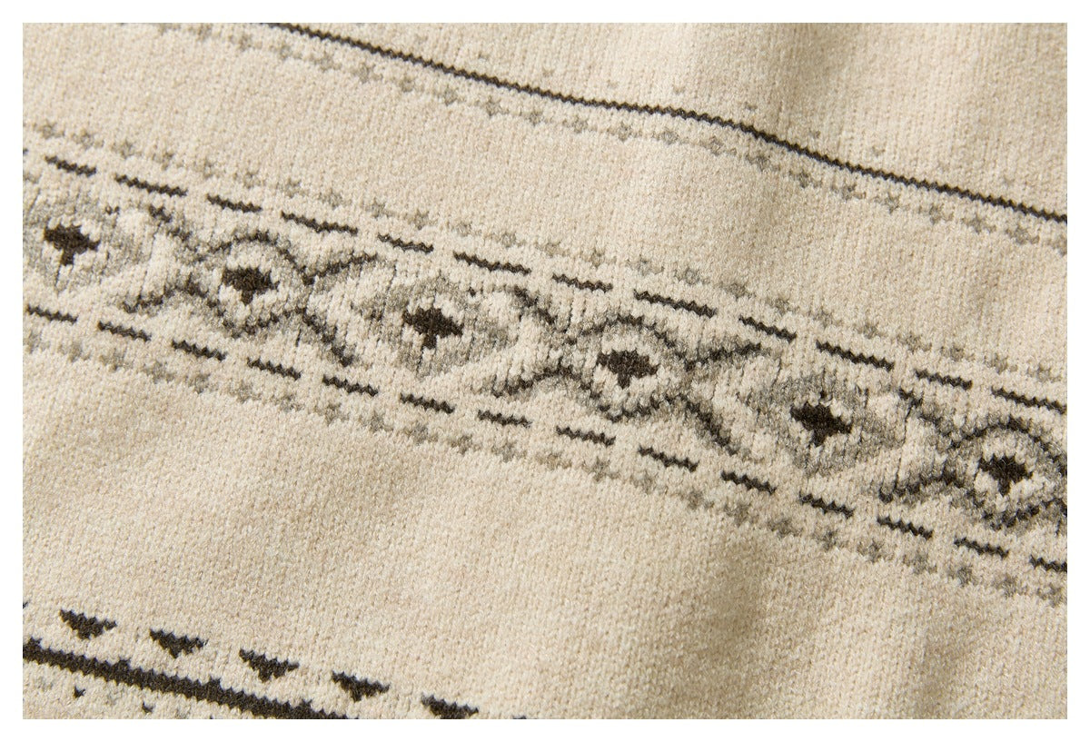 Close-up of the cream knit cardigan's dark geometric patterned band and textured knit stitches.