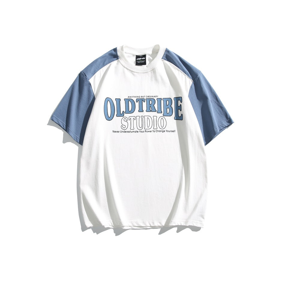White short-sleeve T-shirt with blue sleeves and a blue OLDTRIBE STUDIO block-letter graphic on the front