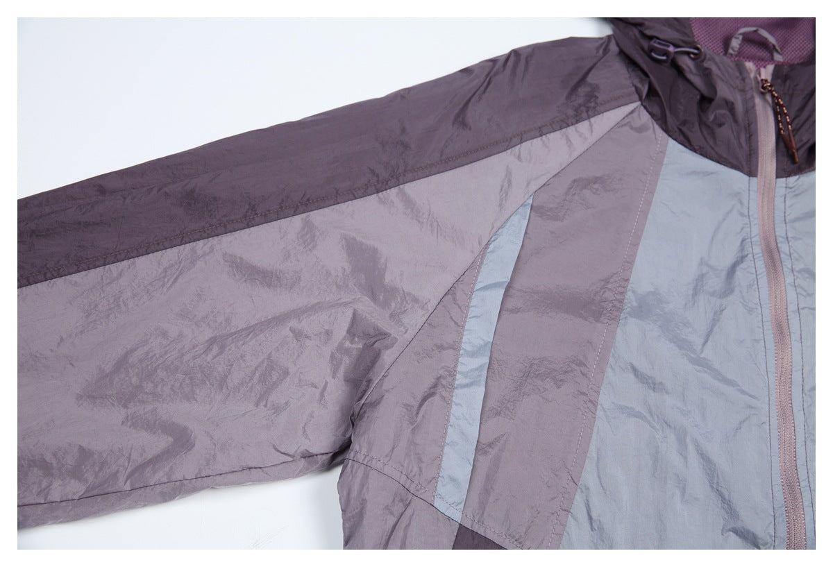 Close-up of a sleeve and front panel showing the jacket's purple, lavender, and pale blue color blocking.