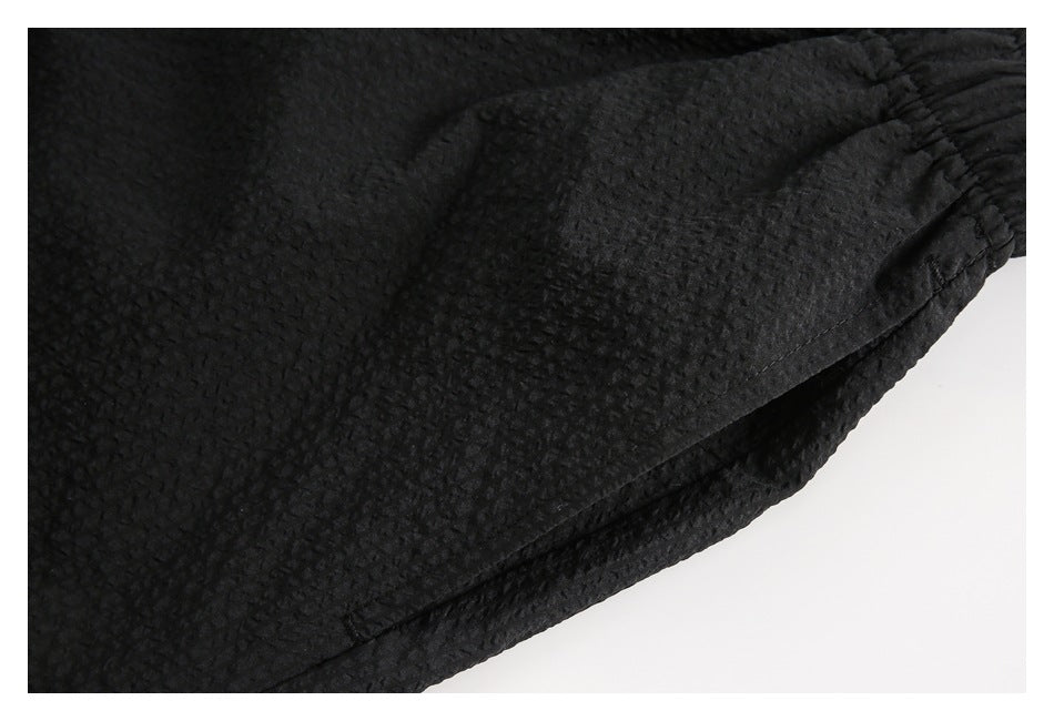 Close-up of the black shorts' textured fabric and side seam.