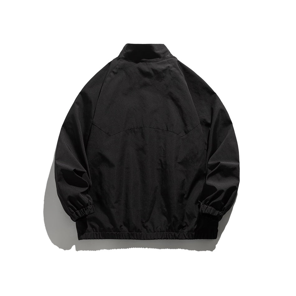 Back view of a plain black jacket with a stand collar, curved back seam, raglan sleeves, and elastic cuffs.