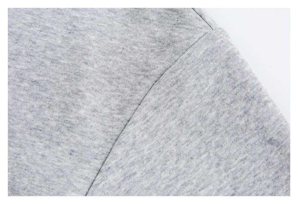 Close-up of a seam on light gray marled knit fabric.